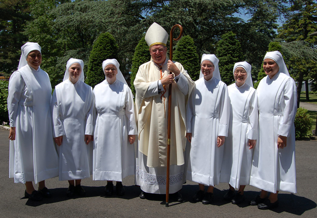 New York Cardinal Timothy Dolan stands with sisters who made their first vows June 1 with the Little Sisters of the Poor, an order of religious women that runs a nursing home in Philadelphia.