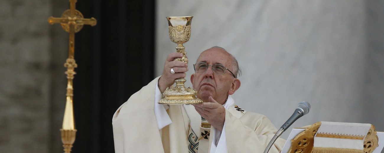 Pope Francis raises the Eucharist as he celebrates Mass marking the feast of Corpus Christi outside the Basilica of St. John Lateran in Rome May 26. (CNS photo/Paul Haring)