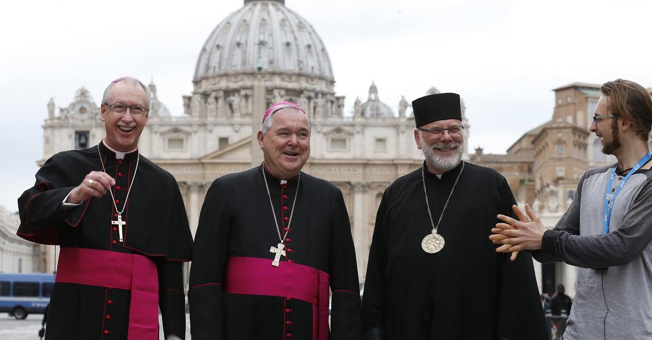 Seamus McKelvey of Winnipeg, Manitoba, crashes a group photo with Canadian bishops in front of St. Peter's Basilica March 27. From left are Archbishops Richard Smith of Edmonton, Alberta; Richard Gagnon of Winnipeg, Manitoba; and Bishop Kenneth Nowakowski of the Ukrainian Diocese of New Westminster, British Columbia. The bishops were making their "ad limina" visits to the Vatican to report on the status of their dioceses. (CNS photo/Paul Haring)
