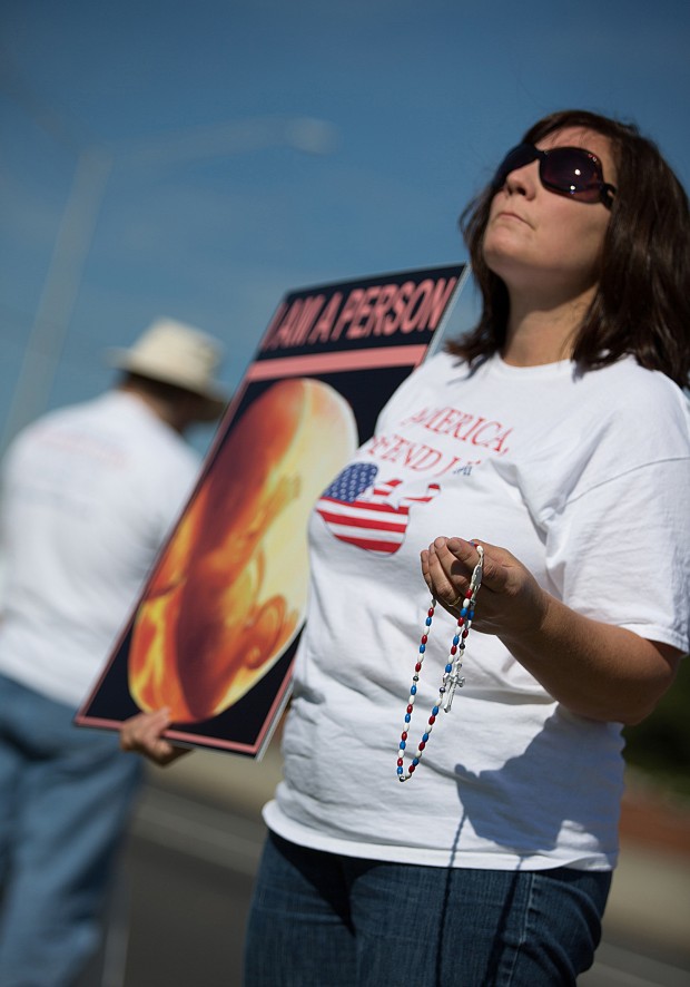 A woman from the pro-life grassroots organization America, Defend Life! prays the rosary during a demonstration outside a Planned Parenthood center in Charlotte, N.C., Sept. 1. Cecile Richards, president of Planned Parenthood Action Fund, and Nancy Keenan, president of NARAL Pro-Choice America, were among the scheduled speakers at the 2012 Democratic National Convention being held in Charlotte Sept. 4-6. (CNS photo/Anthony Perlas, Catholic News Herald)