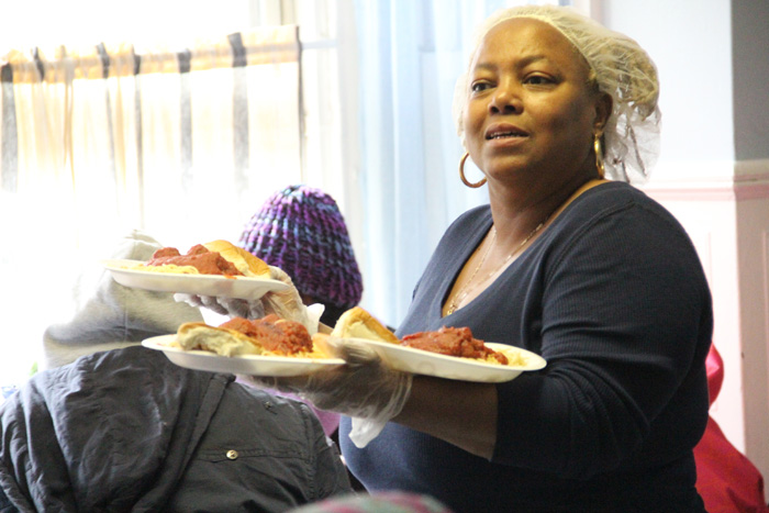 Elaine Nelson, food service manager at Mercy Hospice, dishes out hot plates of spaghetti and meatballs to guests at the CSS facility for homeless women and their children Feb. 13. (Sarah Webb)