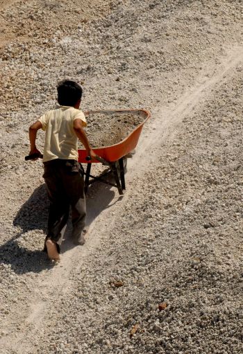 In this Feb. 22, 2008, file photo, a boy carries rubble from a pumice stone mine near Managua, Nicaragua. (CNS photo/Mario Lopez, EPA) 
