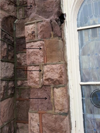 A detailed view of the exterior of the church shows the deterioration and vertical cracks of the brownstone facing stones.