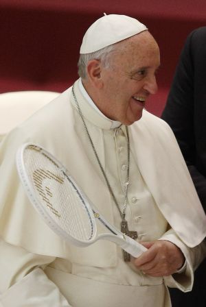 Pope Francis holds a tennis racket he received during an audience with the Italian Tennis Federation in Paul VI hall at the Vatican May 8. (CNS photo/Paul Haring) 