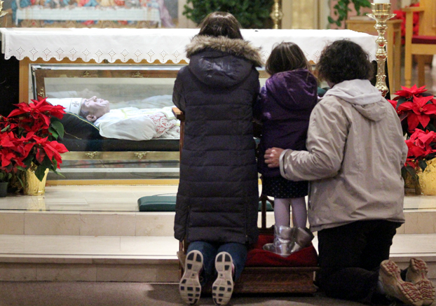 Jennifer Ruppersberger, Tessa Ruppersberger and Carolyn Wise pray before St. John Neumann at his tomb in the shrine dedicated to the saintly former bishop of Philadelphia (Sarah Webb)