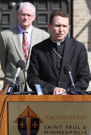 Auxiliary Bishop Andrew H. Cozzens of St. Paul and Minneapolis speaks during a June 5 news conference outside of the chancery after the Ramsey County Attorney's Office criminally charged the archdiocese for failing to protect children. Behind him is Judge Tim O'Malley, archdiocesan director of ministerial standards and safe environment. (CNS photo Dave Hrbacek, The Catholic Spirit) 