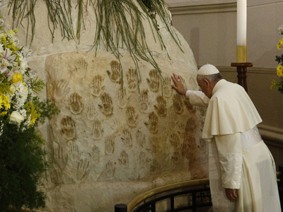 Pope Francis touches the base of the statue of Our Lady of Caacupe before celebrating Mass outside the Caacupe Marian Shrine in Asuncion, Paraguay, July 11. (CNS photo/Paul Haring) 