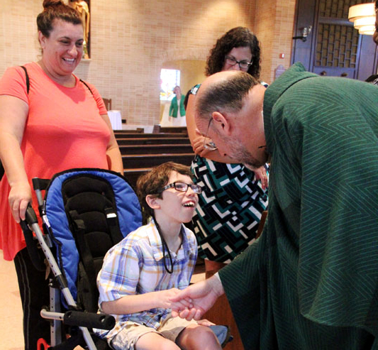Fr Hallinan greets Cameron Sperduto and his mom Leann after mass