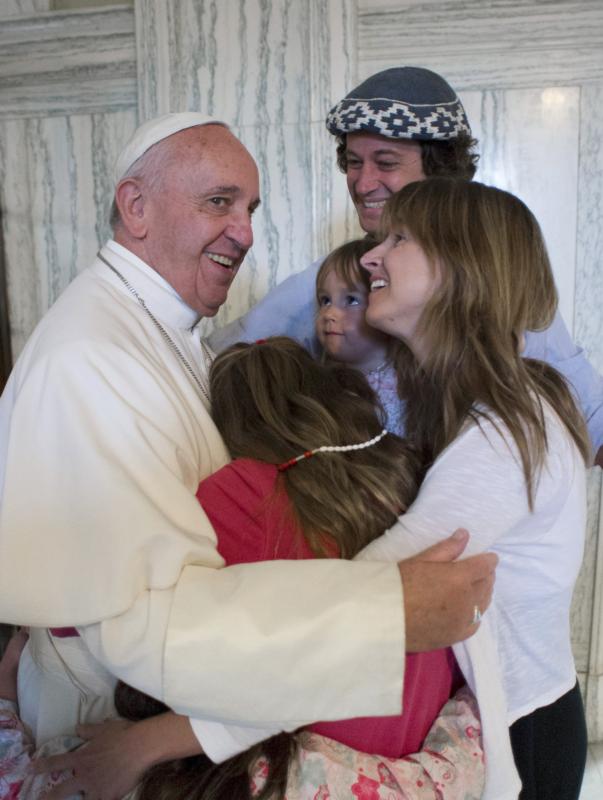 Pope Francis embraces the Walker family of Buenos Aires, Argentina, Sept. 27 in Philadelphia. Catire, Noel and their four children -- Cala, 12, Dimas, 8, Mia, 5, and Carmin, 3 -- traveled 13,000 miles to be with Pope Francis during the World Meeting of Families. (CNS photo/L'Osservatore Romano via Reuters) See PAPALTRIP-FAMILY-ARGENTINA Sept. 28, 2015.