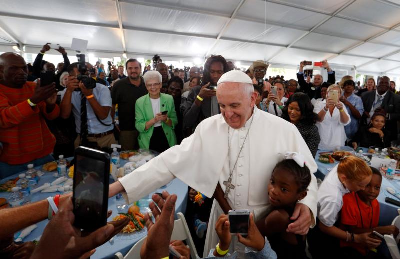 A girl hugs Pope Francis as he visits with people at St. Maria's Meals Program of Catholic Charities in Washington Sept. 24. (CNS photo/Paul Haring) See POPE-HOMELESS Sept. 24, 2015.