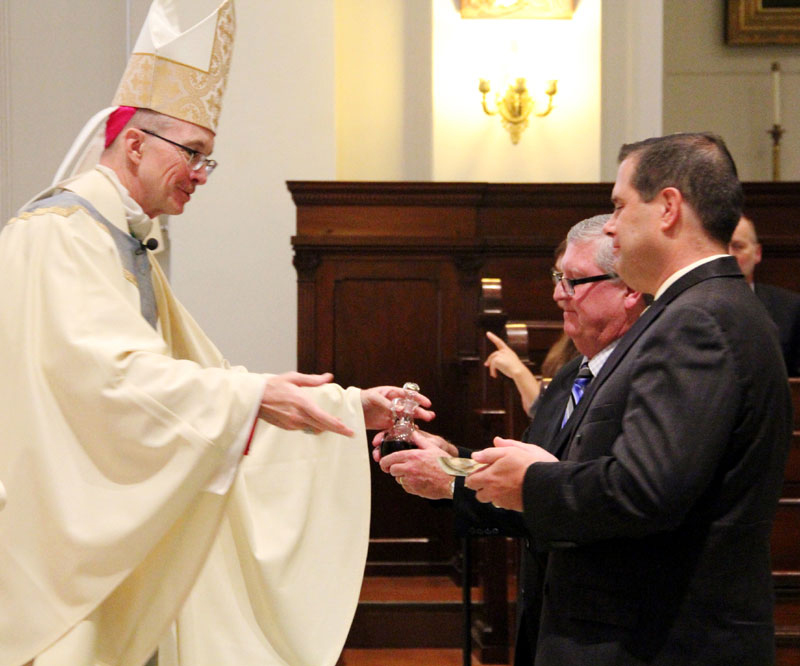 Gerald J. Cassidy and Joseph P. Boyle present the gifts to Bishop Timothy Senior.