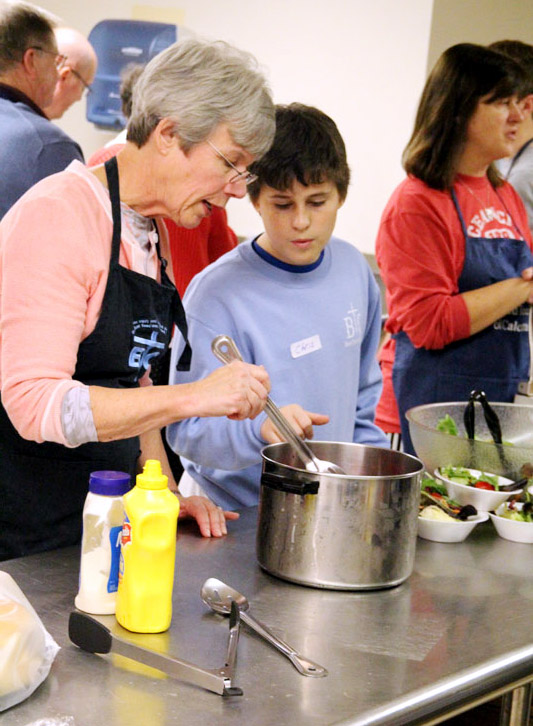 Rosemary Whitehouse and Christopher Beehler stir beets to be served as they volunteer during the year of mercy.