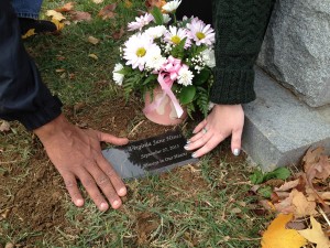 Mary McCarthy Hines and her husband, Charles, touch the grave of their stillborn daughter, Virginia, in late October. "A m.o.m.s. peace" helped order and install a grave marker for Virginia and honor her life through a remembrance program. (CNS photo/courtesy Kara Palladino)