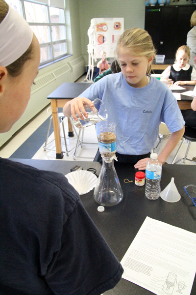 Students measure carefully in a science experiment at St. Patrick School, Malvern. (Sarah Webb)