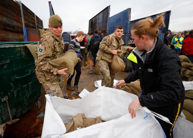Local volunteers and the British Army fill sandbags Dec. 28 to stem floodwater in York, England. (CNS photo/Lindsey Parnaby, EPA) 