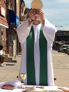 Father Joseph Devlin celebrates Mass on the sidewalk outside Mother Mercy House in Kensington.