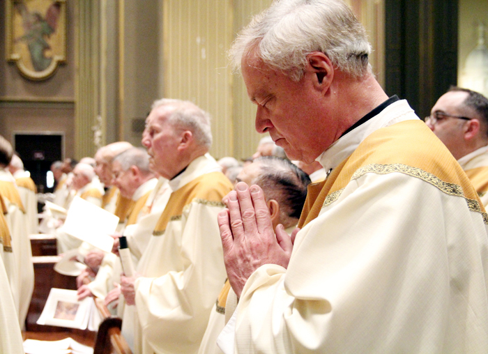 Father Edward Kelty, home from his assignment in Rome, prays on Holy Thursday.