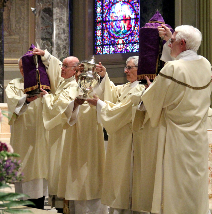 The holy oils are brought to the altar for Archbishop Charles Chaput to bless which the priests of the Archdiocese will use in the sacraments of the church throughout the the year.