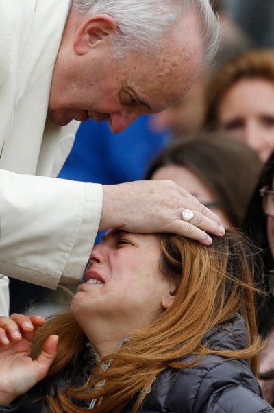 Pope Francis blesses a woman while meeting the disabled during his general audience in St. Peter's Square at the Vatican March 23. (CNS photo/Paul Haring)