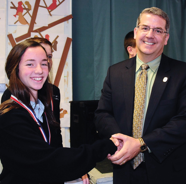Anna Castagno is presented with a $5,000 scholarship award to attend Cardinal O'Hara High School by school President Tom Fertal. Castagno won first place in the Oration category of the declamation contest  by reciting Jean Valjean’s soliloquy from the play “Les Miserables.” 