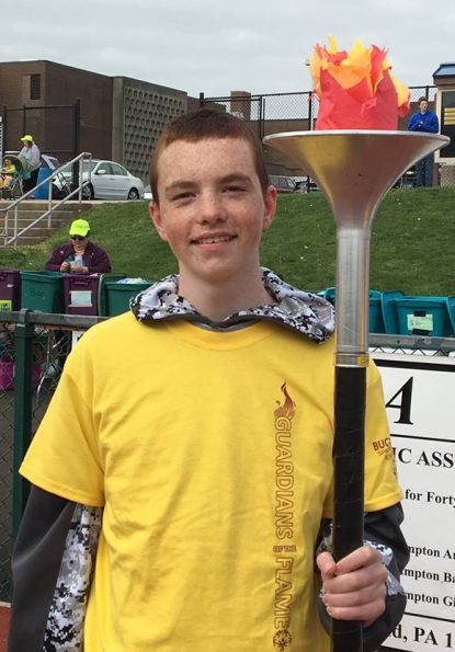 Conor Milligan holds the torch prior to a track meet in which he and his brother competed.