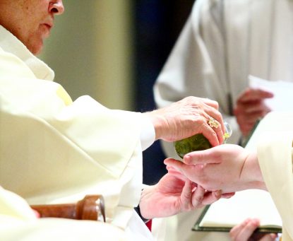 Archbishop Chaput anoints the hands of Father Matthew Windle during the ordination rite. The cloth used to clean Father Windle's hands of the sacred chrism was given to his mother, Marie Windle.