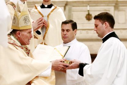 Kyle Adamczyk (right), a Second Theology seminarian studying for the Philadelphia Archdiocese, receives the ministry of acolyte from Bishop David O'Connell. With reception of the ministry, Adamczyk is on track to be ordained a transitional deacon next year, and eventually a priest in 2018. (Sarah Webb) 