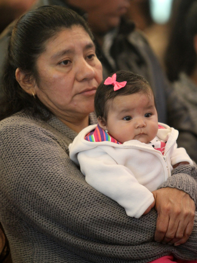 A woman holds a baby during a Spanish-language Mass honoring immigrants at St. John the Evangelist Church in Riverhead, N.Y., in 2011. (CNS photo/Gregory A. Shemitz)