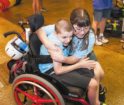 Buddy Break volunteer Rebekah Layne greets VIP Noah Ankey with a hug Aug. 19 at St. Stephen Church in Old Hickory, Tenn. At Buddy Break, which offers respite for parents, each VIP child is assigned one buddy to stay with them for the entire evening to ensure they are safe and having fun. (CNS photo/Theresa Laurence, Tennessee Register) See BUDDY-BREAK-RESPITE Sept. 1, 2016.