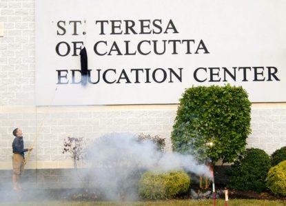 A student of the parish school helps unveil the newly renamed St. Teresa of Calcutta Education Center in a ceremony at the parish in Limerick. Sarah Webb)