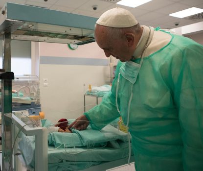 Pope Francis touches a baby as he visits the neonatal unit at San Giovanni Hospital in Rome Sept. 16. (CNS photo/L'Osservatore Romano, handout)