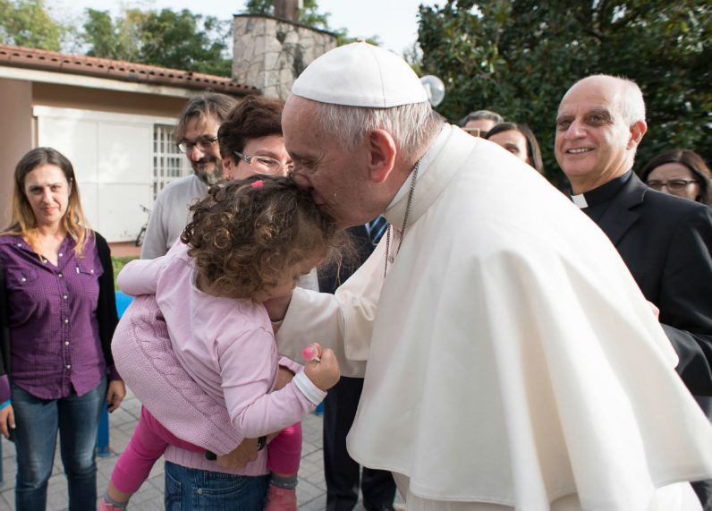 Pope Francis kisses a girl during an Oct. 14 visit to Rome's SOS Children's Village. The village, which includes five houses, attempts to provide a home-like atmosphere for children under the age of 12 whose parents cannot care for them. (CNS photo/L'Osservatore Romano) 