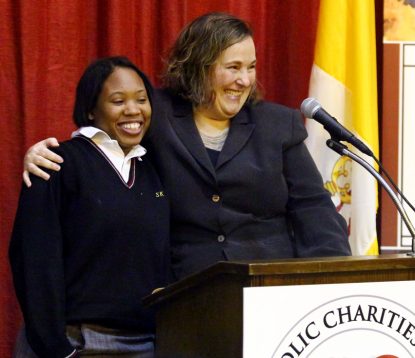 Kathleen Gould (right), principal of St. Katherine Day School, tells guests at the school Jan. 18 how Tamika (left) wanted to learn how to count change and work in a nursing home. By helping Tamika focus on doing her personal best, she is achieving her goals. (Sarah Webb)