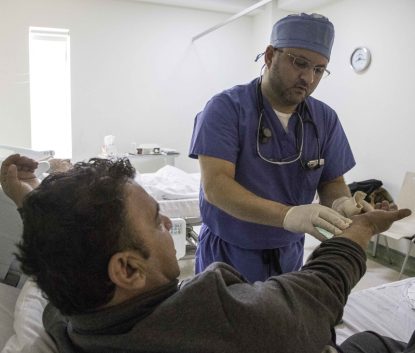 Dr. Anas Safadi, a cardiologist with the Syrian American Medical Society, checks his Syrian refugee patient Jan. 11 at Gardens Hospital in Amman, Jordan, after performing free heart catheter surgery the previous day. (CNS photo/Scott R. Carey)
