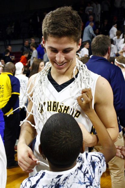 A young fan looks up to Archbishop Wood's standout player, Collin Gillespie as he wears the freshly cut net around his neck after the Catholic League championship game. (Sarah Webb)