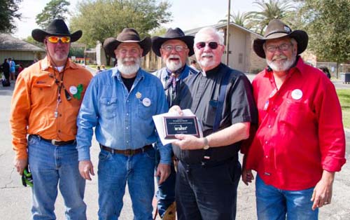 Members of the Sam Houston Trail Riders present Father Benjamin Smaistrla of St. Ambrose Catholic Church in Houston a plaque of appreciation March 3. (CNS photo/James Ramos, Texas Catholic Herald)  