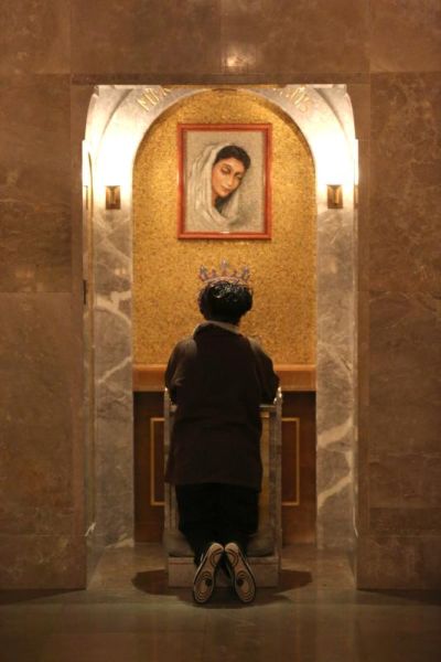 A woman prays in front of an image of Mary March 1 in the Crypt Church at the Basilica of the National Shrine of the Immaculate Conception in Washington. Appreciating artistic beauty leads to an experience of contemplation as "a gaze of faith, fixed on Jesus." (CNS photo/Bob Roller).
