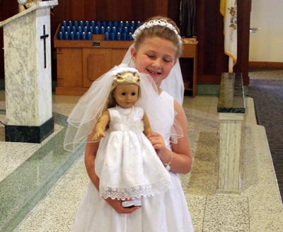 Madison Prichard is proud not only to receive first holy Communion but also of her doll Isabella, which is also wearing a communion dress given as a gift for the occasion.