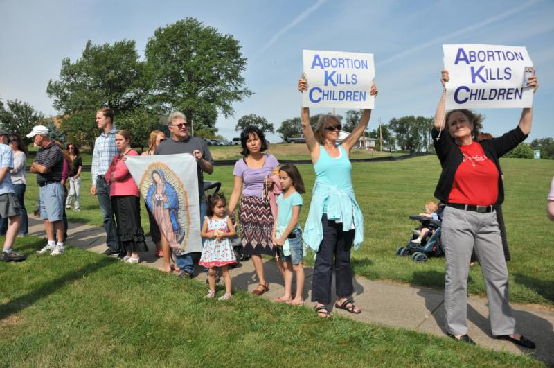 People hold pro-life signs in front of Planned Parenthood in Bettendorf, Iowa, in 2015. The Iowa Legislature voted to end Medicaid reimbursements to family planning clinics that do abortions, which includes Planned Parenthood. Four Iowa clinics will close. Three closed June 30 and the Bettendorf clinic was the next to close. (CNS photo/Lindsay Steele, The Catholic Messenger) 