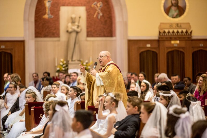 Father Joseph Howarth, former pastor of Resurrection of Our Lord Parish in Philadelphia, preaches the homily at the Mass where children of the parish made their first holy Communion on Saturday, May 6. (Truc Tam)