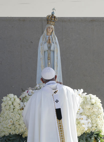 Pope Francis uses incense as he venerates a statue of Our Lady of Fatima during the canonization Mass of Sts. Francisco and Jacinta Marto, two of the three Fatima seers, at the Shrine of Our Lady of Fatima in Portugal, May 13. (CNS photo/Paul Haring)