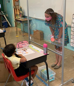 On the first day of school Aug. 31 at Mother Teresa Regional School in King of Prussia, a second-grade teacher and her students make good use of new portable, clear protective screens in the classroom, thanks to a collaboration of the Wayne-based Ambassador's Fund for Catholic Education and West Chester-based Communications Test Design Inc.