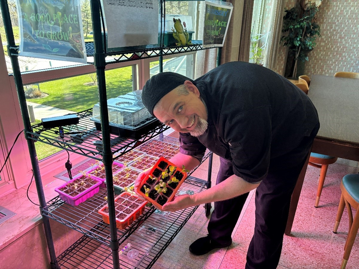 Executive Chef Craig Tinley holding trays of 2024 seedlings prepared for the first season of the Peace Garden at the IHM Motherhouse in Malvern.