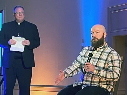 A young adult gives witness to his Catholic faith during a session moderated by Father Stephen DeLacy (left) during The Well conference for young adults Nov. 15 in Philadelphia. (Photo by Jay Sorgi)